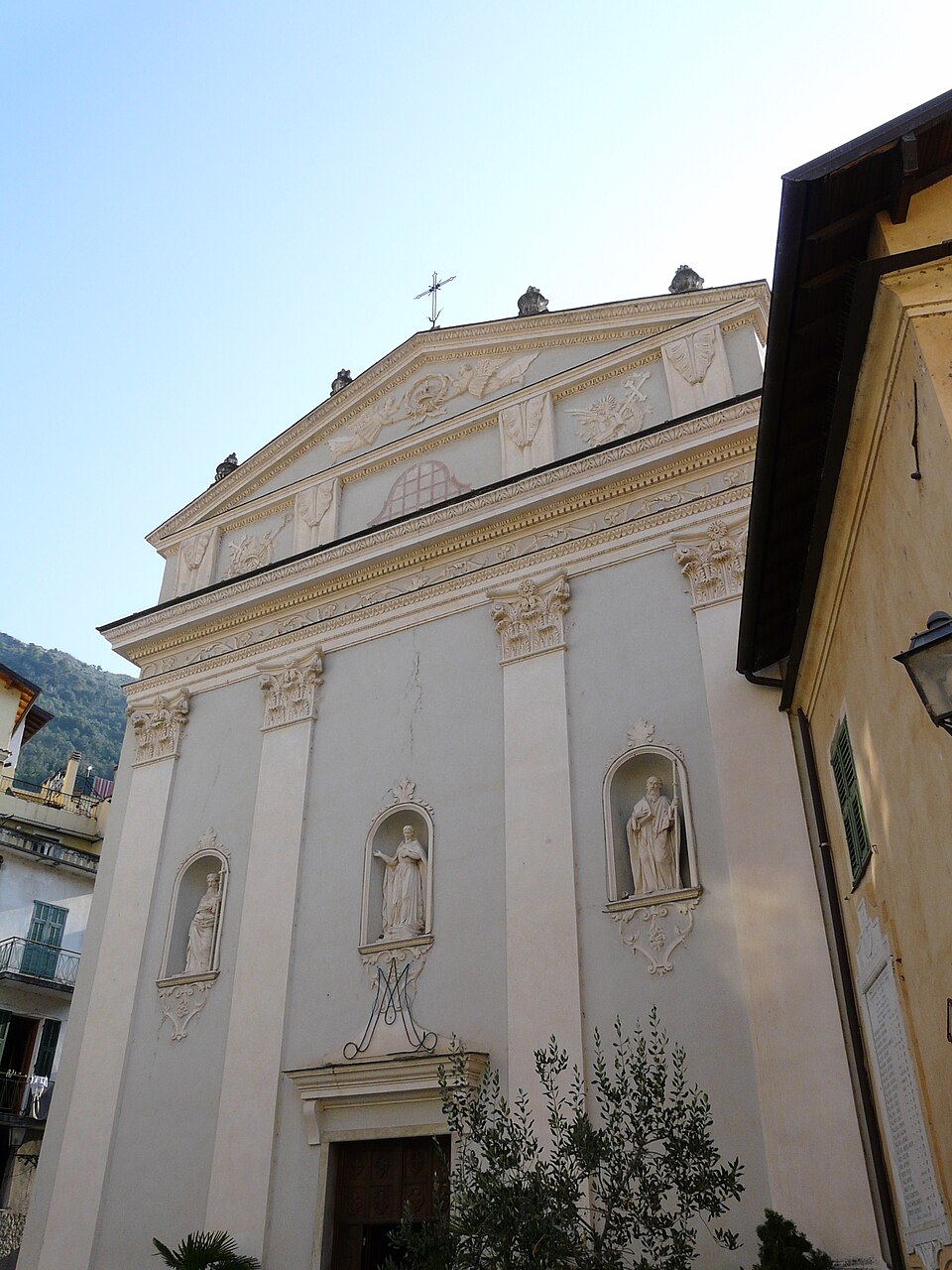 Stone facade and bell tower of the Church of Saints Philip and James in Airole, Liguria