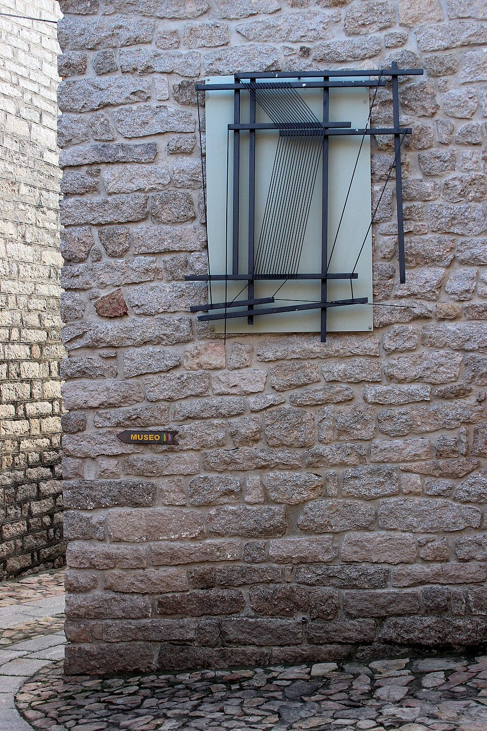 Mural installation by artist Maria Lai on a stone wall in Aggius, Sardinia